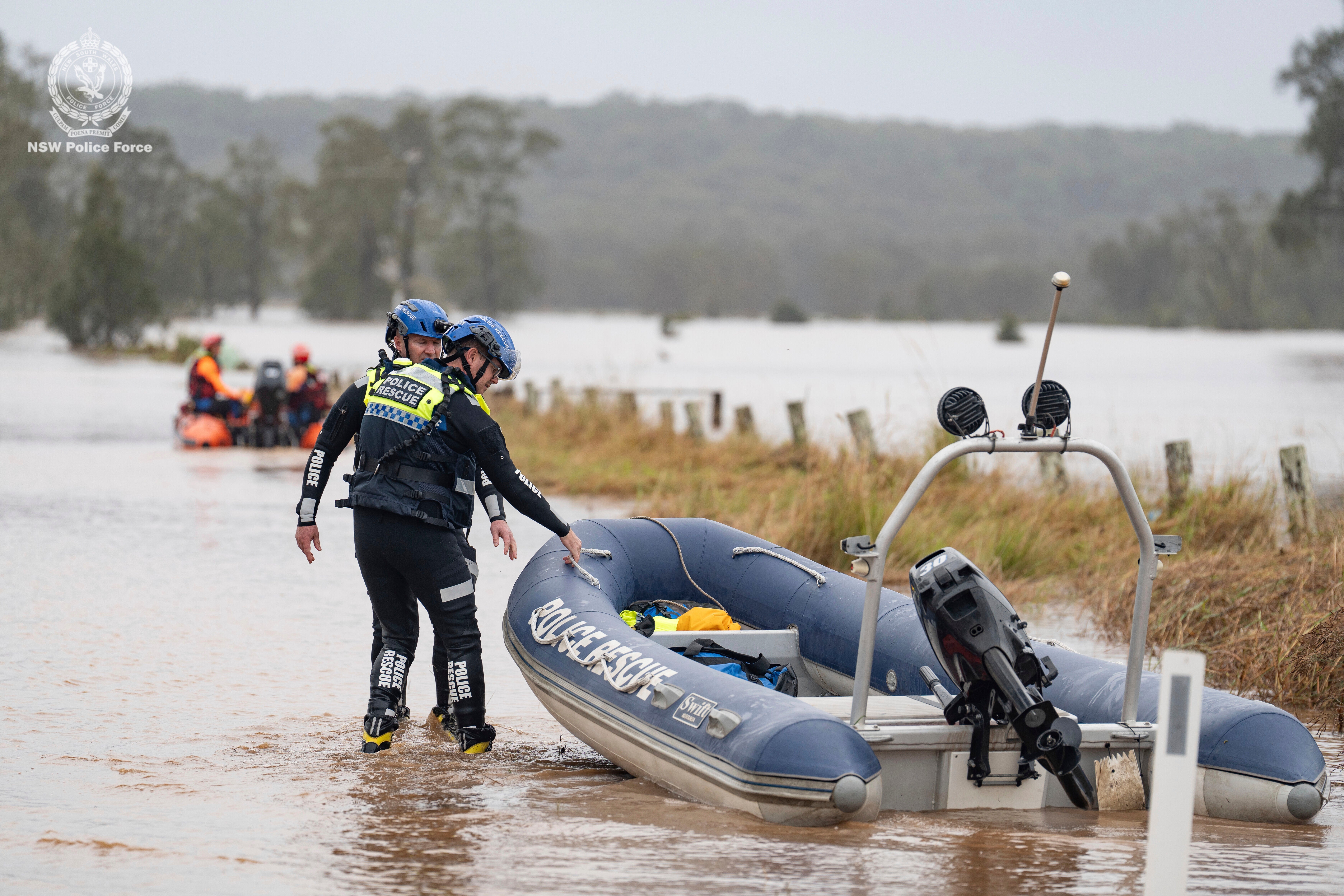 Emergency workers wade through floodwaters as they prepare inflatable boats to effect rescues near Taree, Australia, Thursday, in May