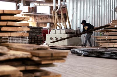 A worker refinishes reclaimed wooden siding at a sawmill in Pine Plains, New York. 