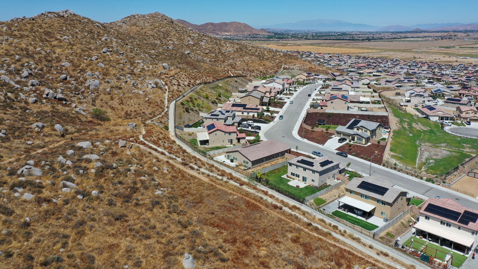 Newly built homes bordering natural hillside vegetation in n the Winchester Ridge development in Winchester, California, on August 18, 2023.