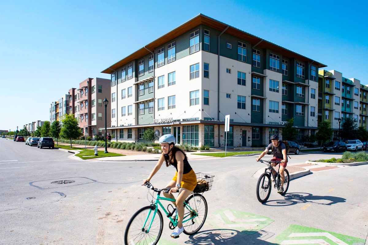 Cyclists in front of large-block multifamily housing in Mueller